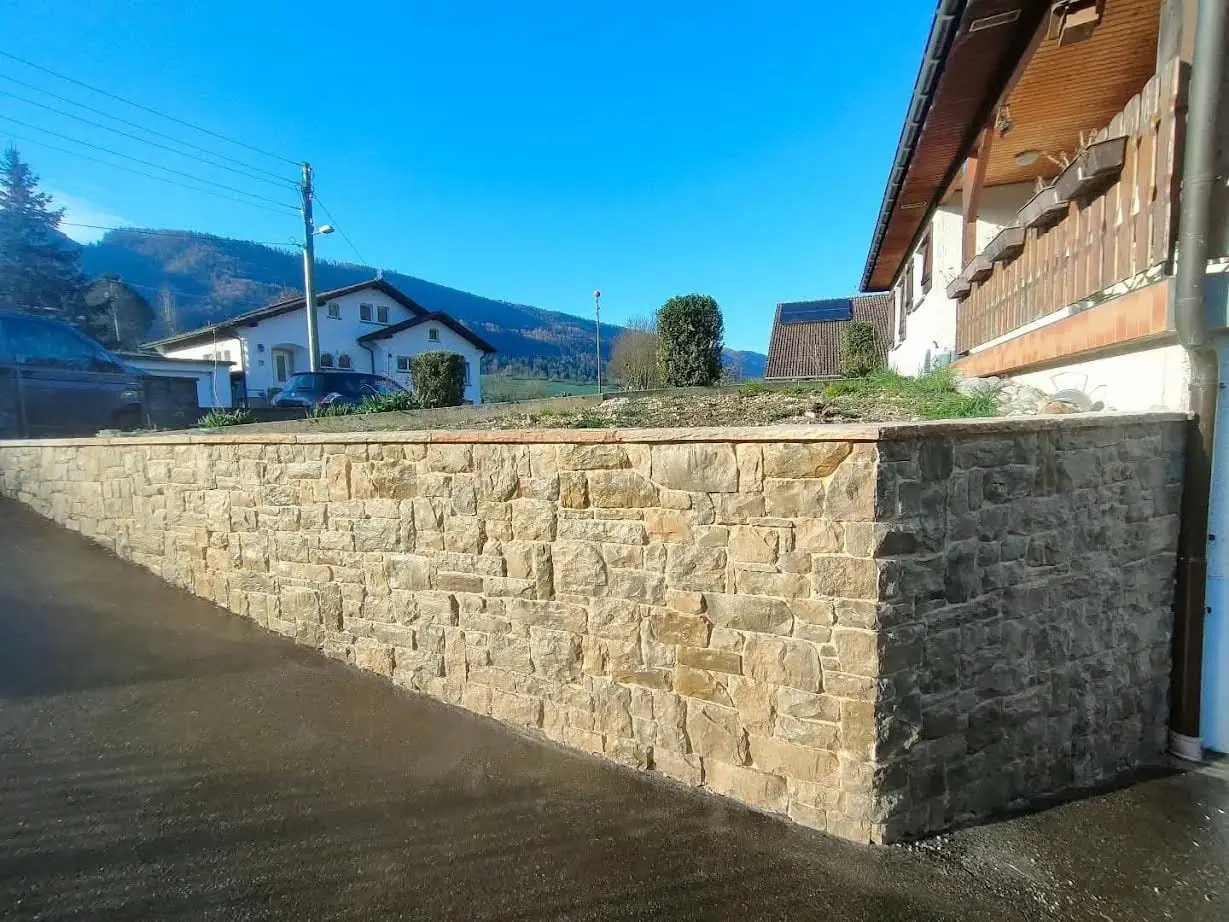 Un mur en béton habillé en pierre naturelle, après travaux