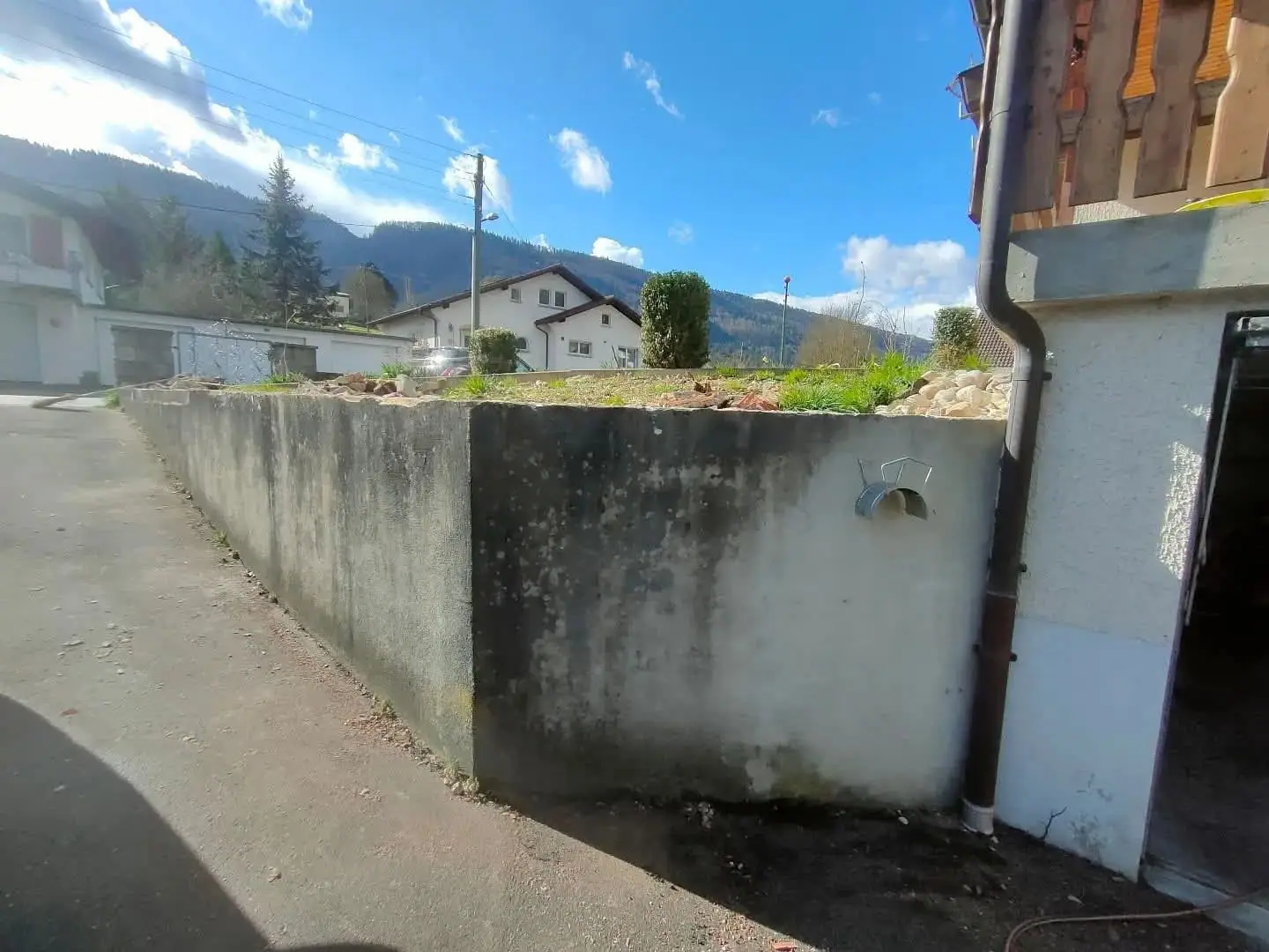 Un mur en béton habillé en pierre naturelle, avant travaux